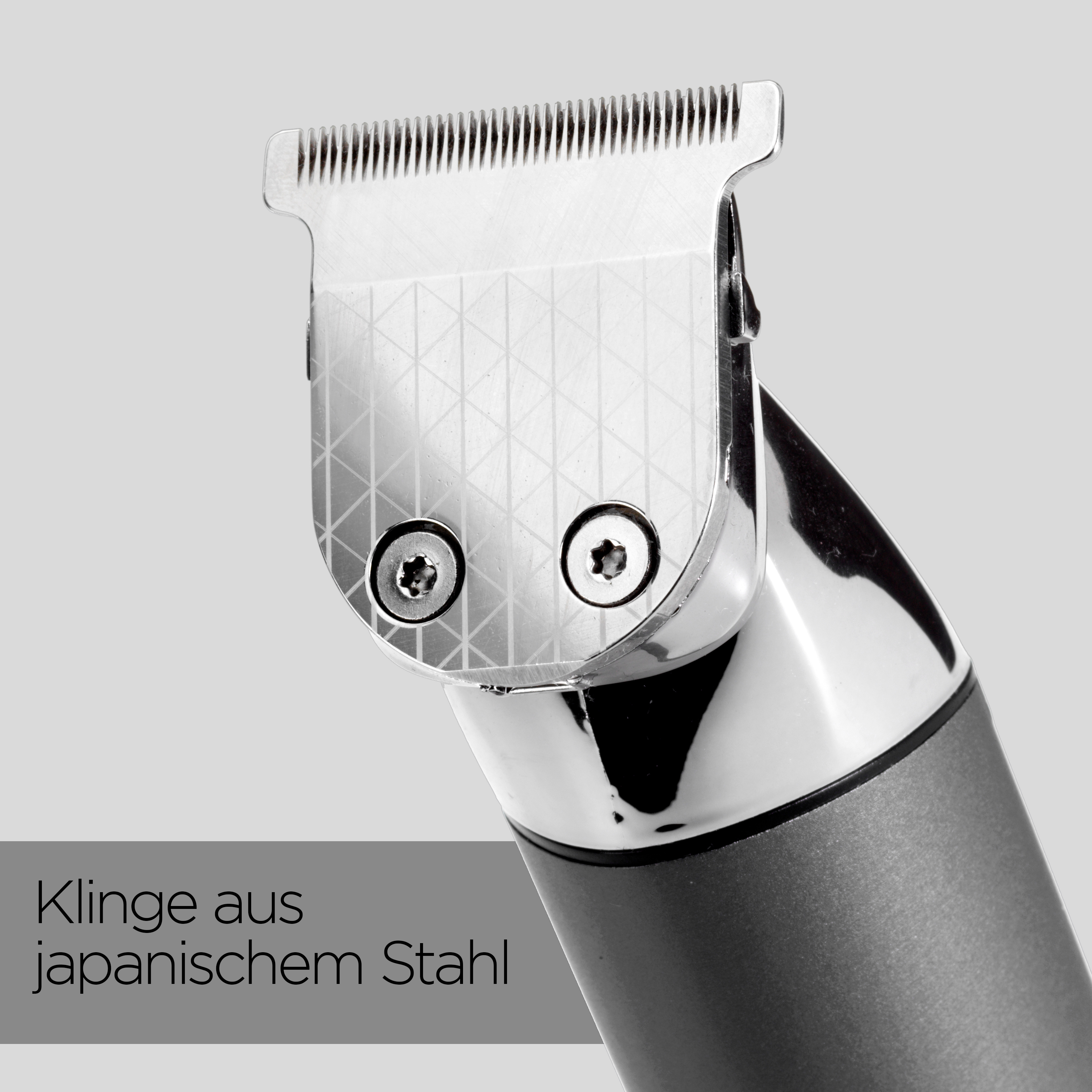 Nahaufnahme eines silbernen Haarschneidekopfes mit gemusterter Oberfläche und japanischer Stahlklinge.