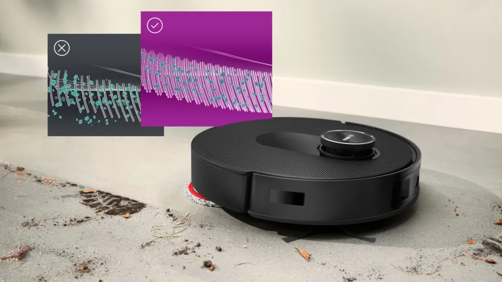 Czarny odkurzacz automatyczny na brudnej podłodze. Dwa diagramy pokazują porównanie czyszczenia.