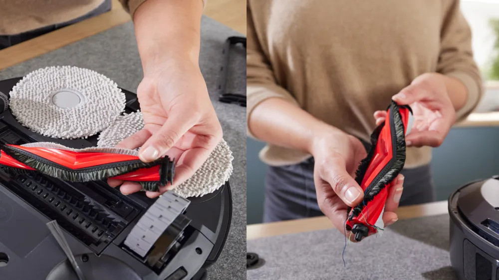 Ręce trzymające czerwoną i czarną szczotkę do odkurzacza. Inne części odkurzacza i pady czyszczące są w tle.