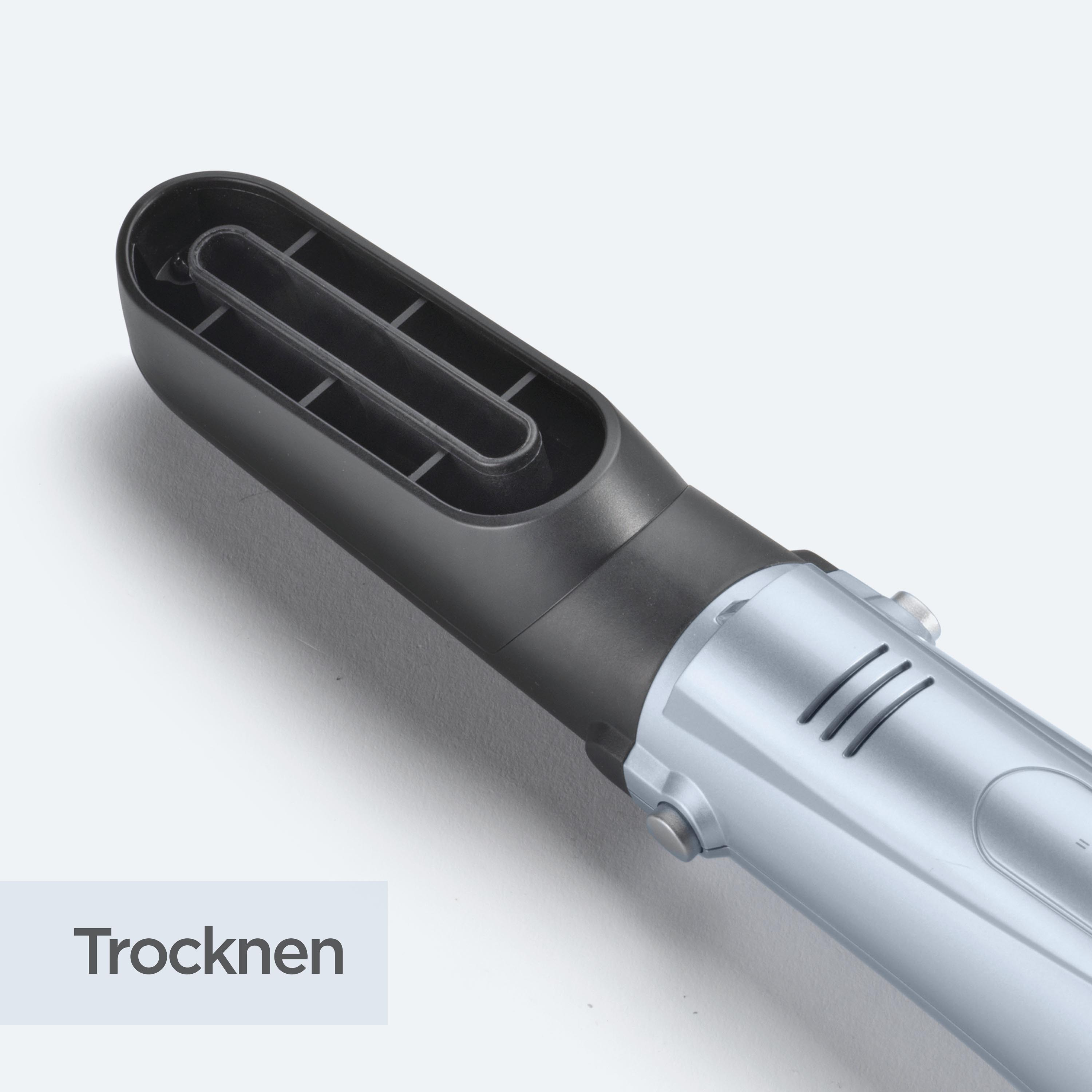 Ein silberner und schwarzer Haartrockner ist auf einer weißen Oberfläche angewinkelt. Das Wort 'Trocknen' wird angezeigt.