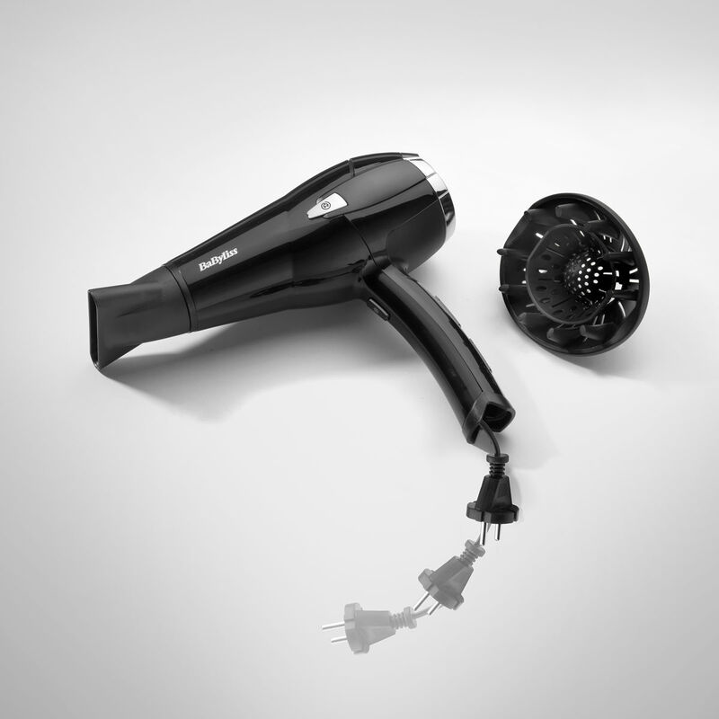 Schwarzer Babyliss-Haartrockner mit Diffusor, Netzstecker und Kabel auf weißem Untergrund. Der Fön ist leicht nach links geneigt.