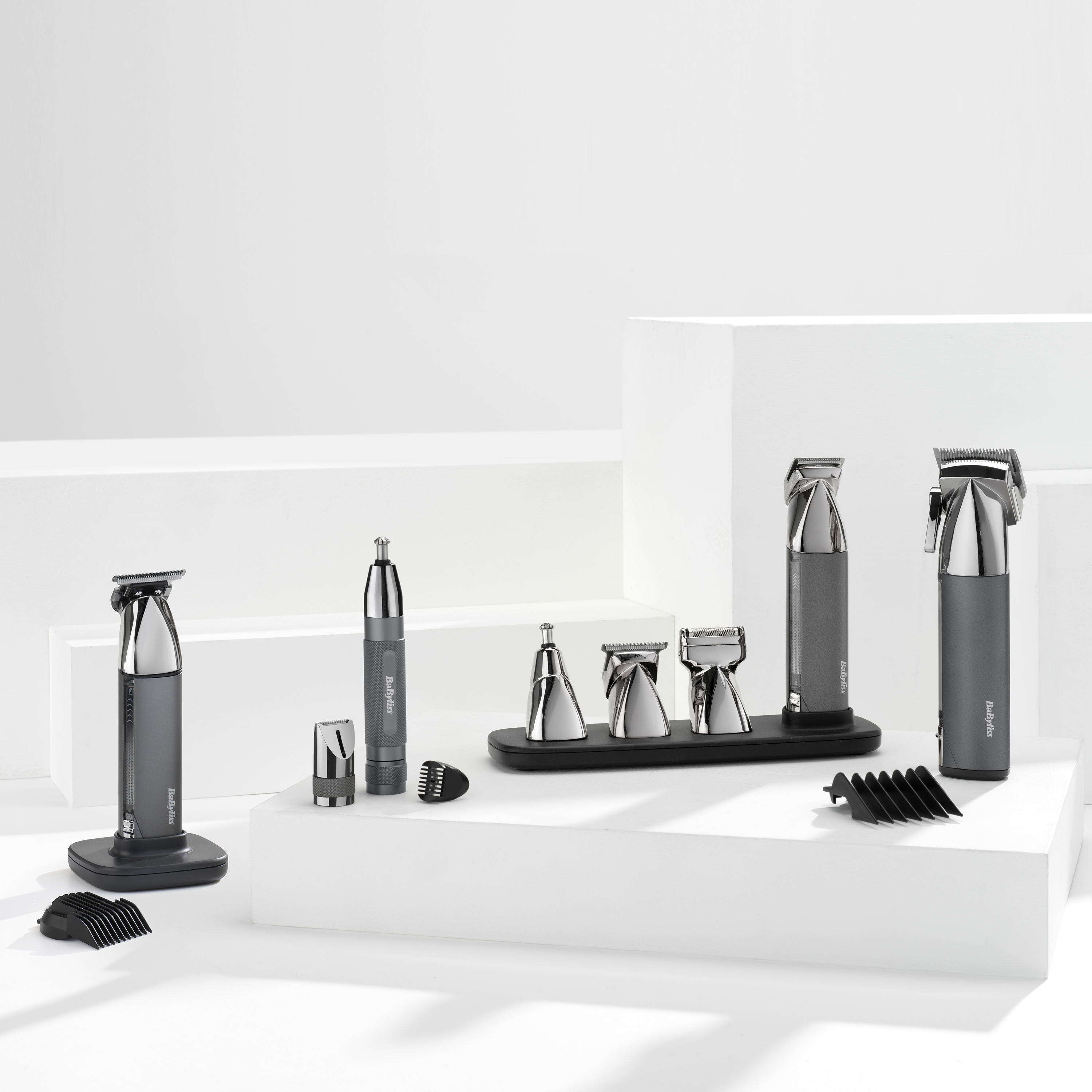 Eine Anzeige von Babyliss-Pflegeprodukten. Es umfasst Trimmer, einen Nasenhaartrimmer und verschiedene Aufsätze auf einer weißen Oberfläche.