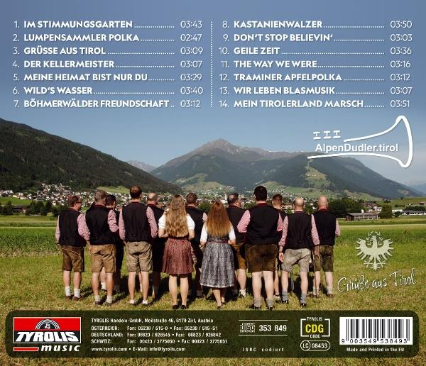 Gruppe von Menschen in Tracht, die auf Gras stehen, mit Bergen und einer Stadt im Hintergrund.