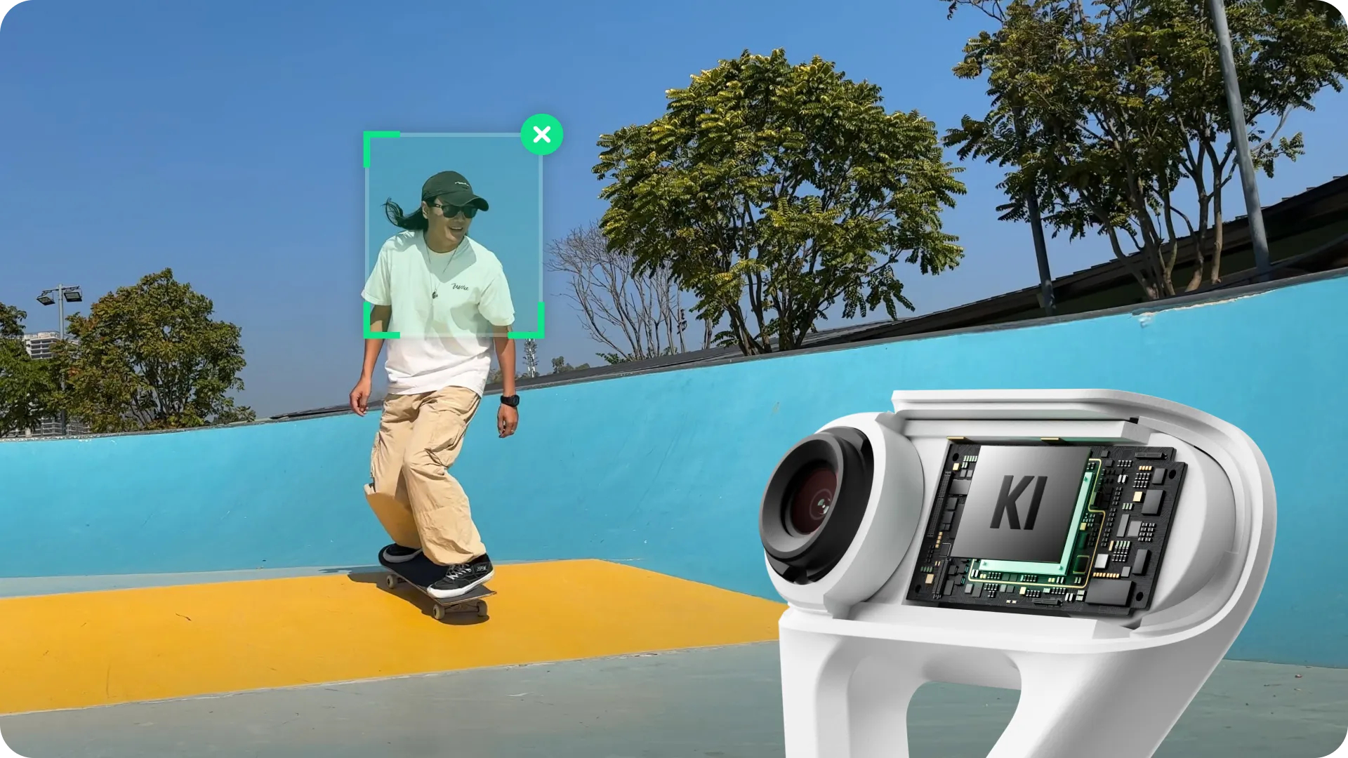 Eine Person, die auf einer gelben Fläche skateboard. Eine Kamera zeigt eine Platine. Im Hintergrund eine blaue Wand und Bäume.