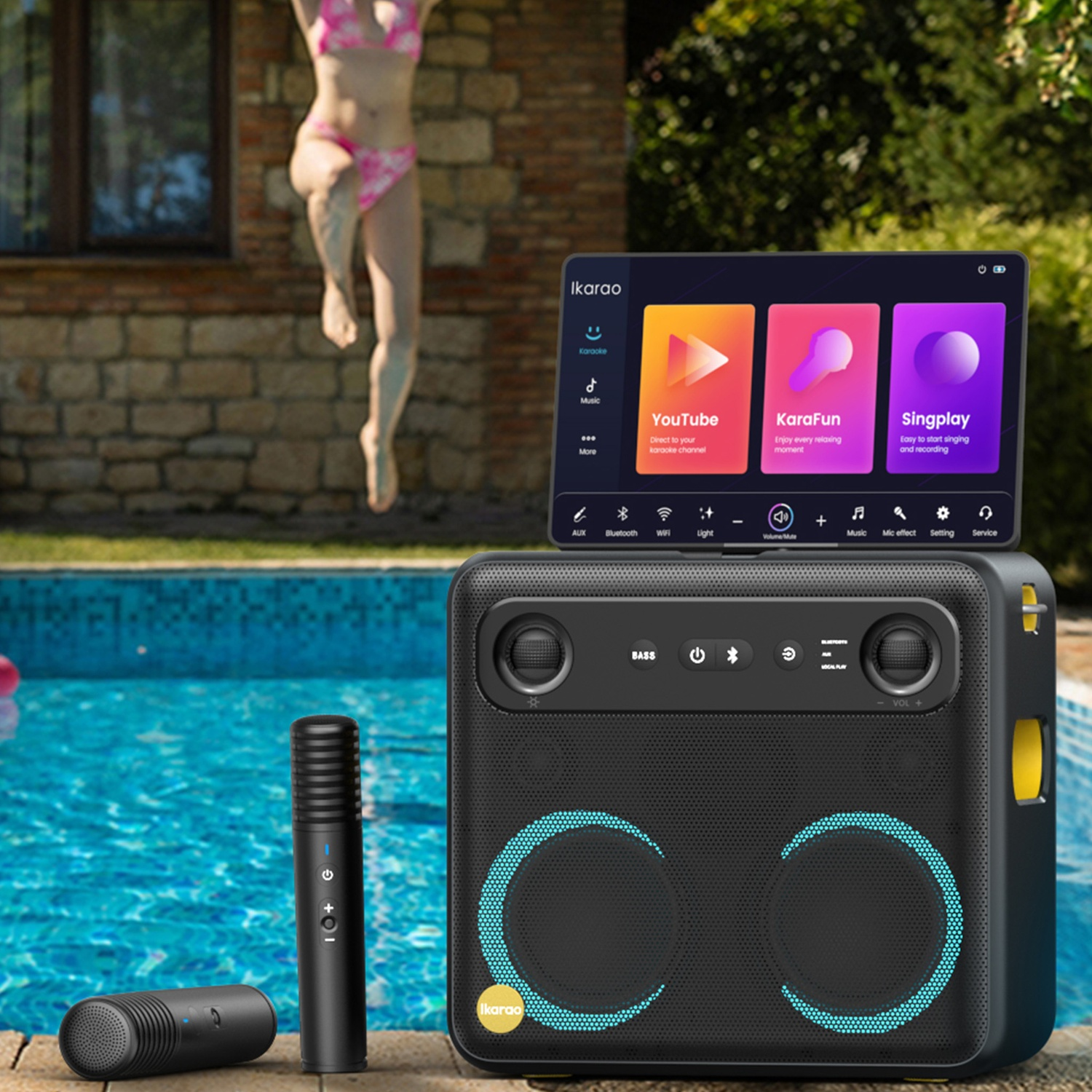Una donna salta in piscina. Un karaoke con schermo mostra YouTube, KaraFun e Singplay. Due microfoni nella scena.