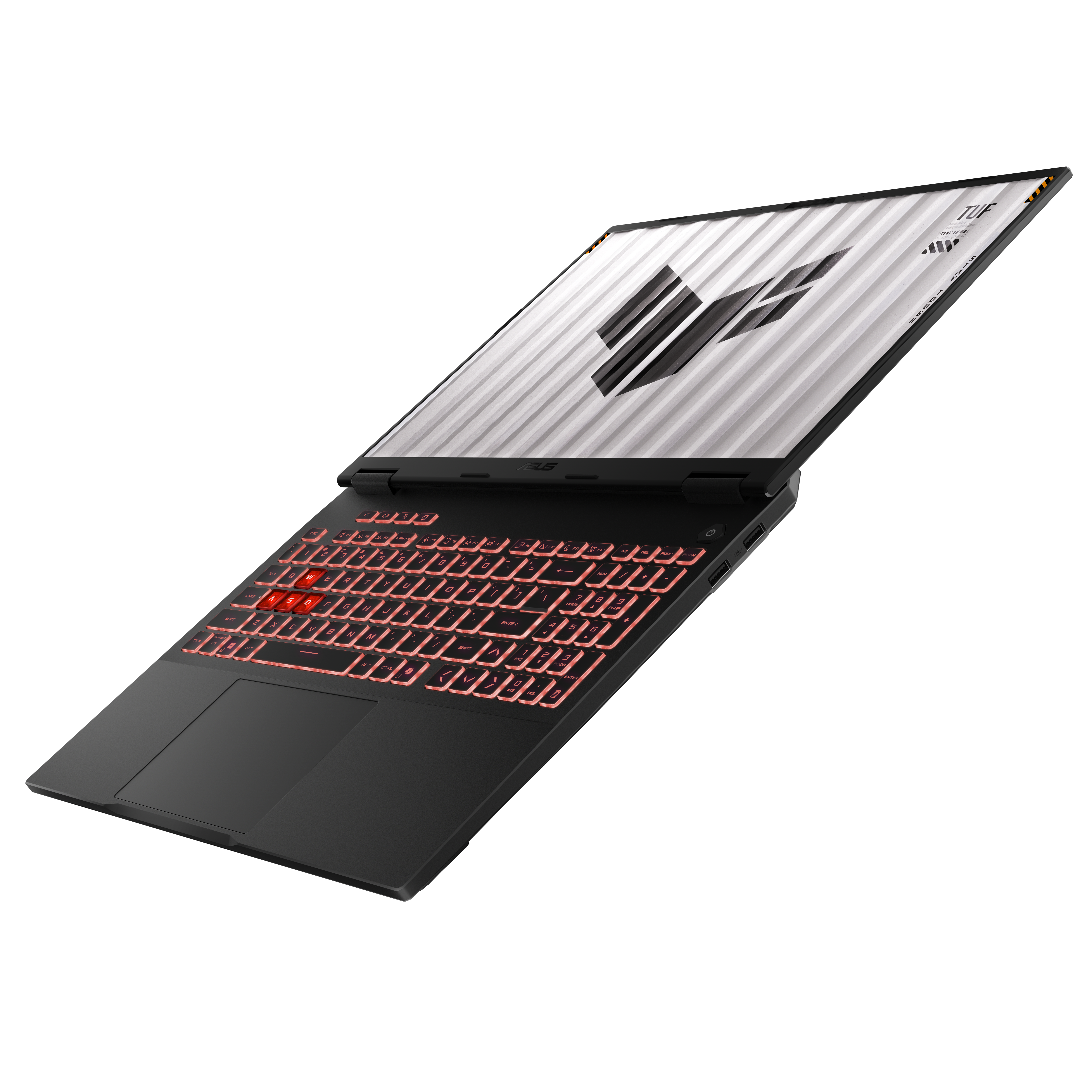 Czarny laptop na czarnej powierzchni. Klawiatura podświetlona na czerwono. Ekran pokazuje logo TUF. Tło jest białe.