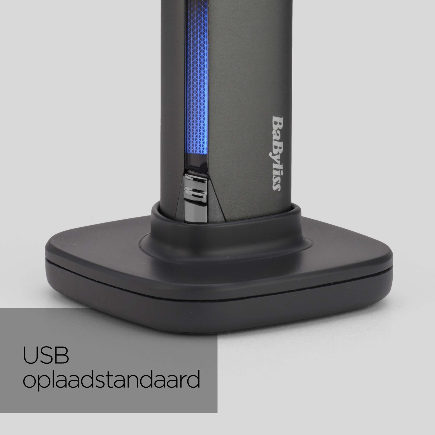 A dark gray Babyliss device on a black charging base. A blue illuminated strip is on the device. Text says 'USB oplaadstandaard'.