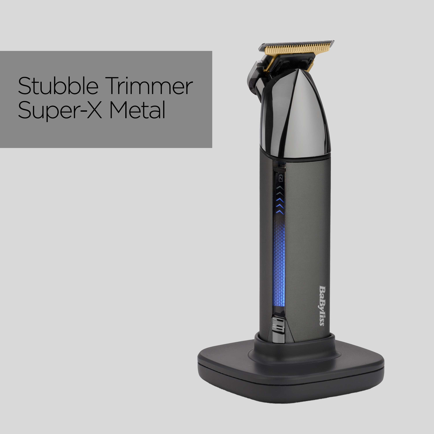 A black and silver Babyliss Super-X Metal stubble trimmer on a stand. The trimmer has a gold blade and a blue light display.