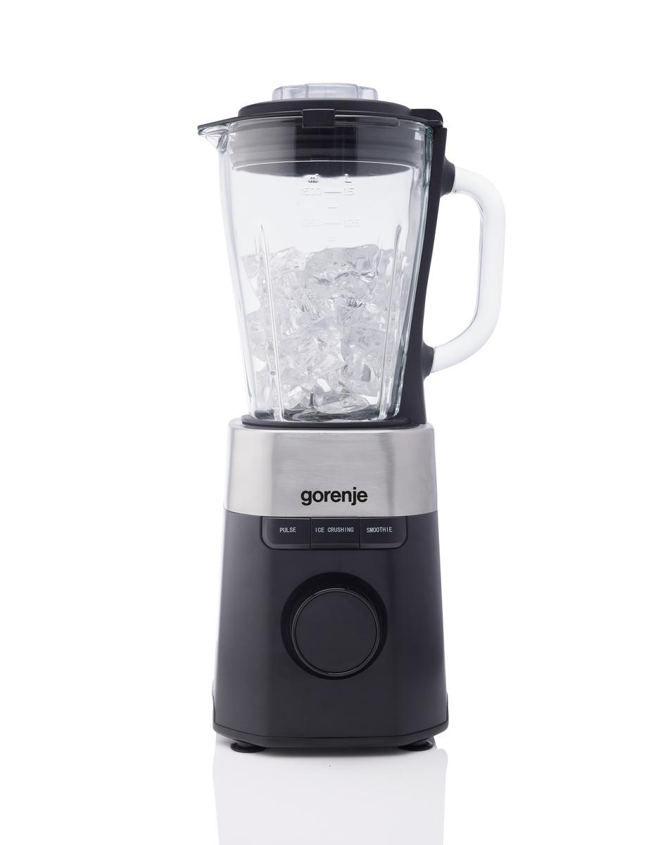Ein Gorenje-Mixer ist mit Eiswürfeln gefüllt. Er hat einen schwarzen Sockel, einen silbernen Aufsatz und einen Glaskrug. Der Griff ist weiß.