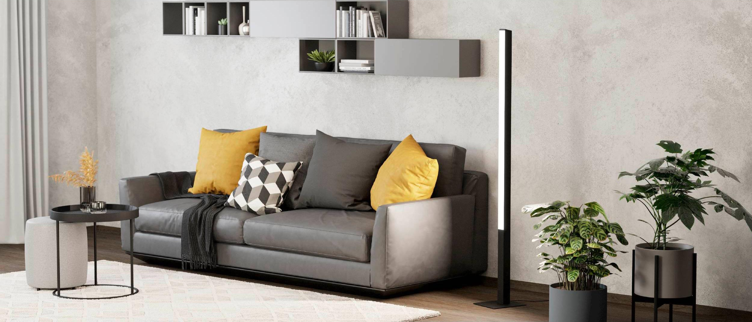 Un moderno soggiorno con divano grigio, cuscini gialli, scaffali, lampada da terra, piante e tavolino con decorazioni.