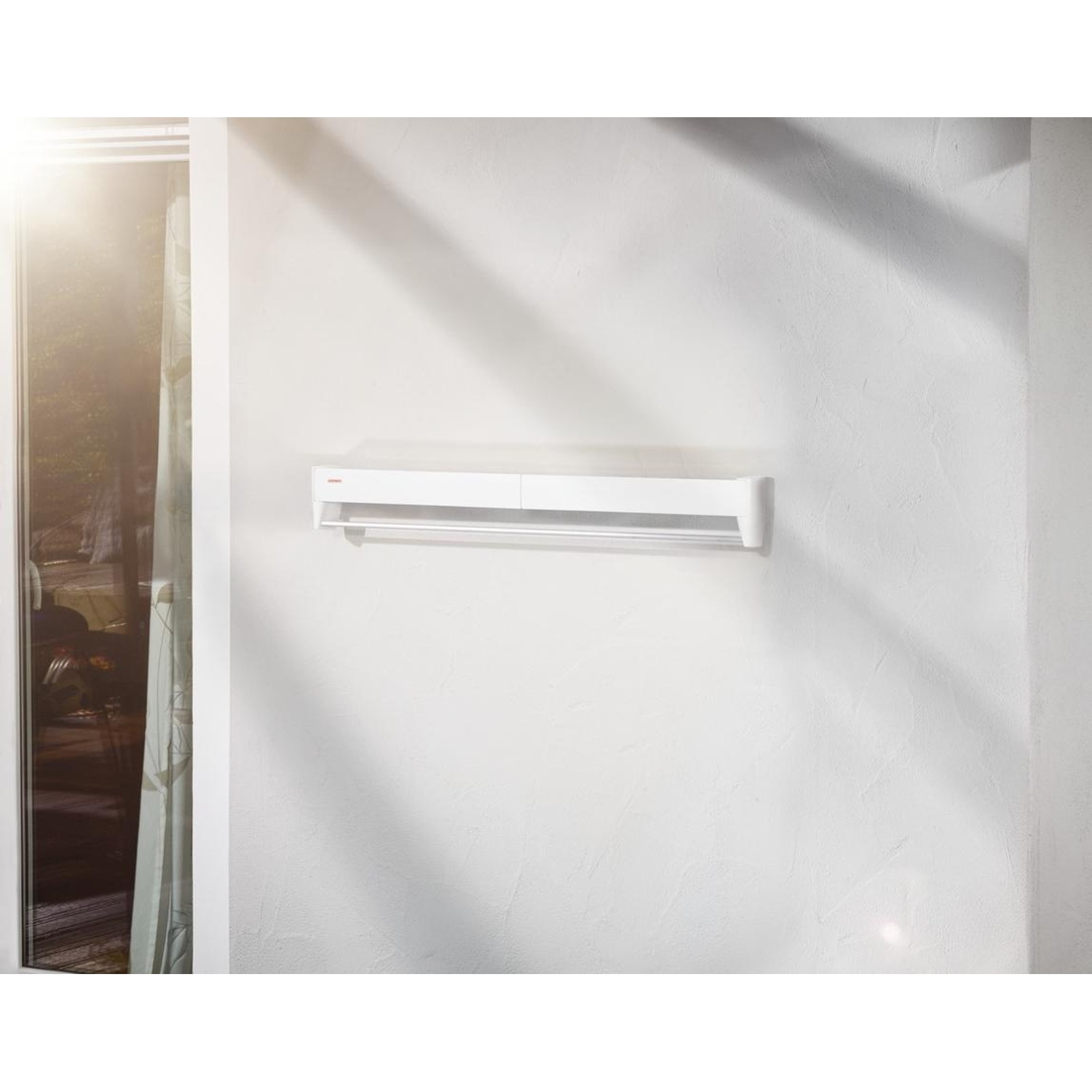 Une étagère blanche murale avec un porte-serviettes. La lumière naturelle entre par une fenêtre à gauche.