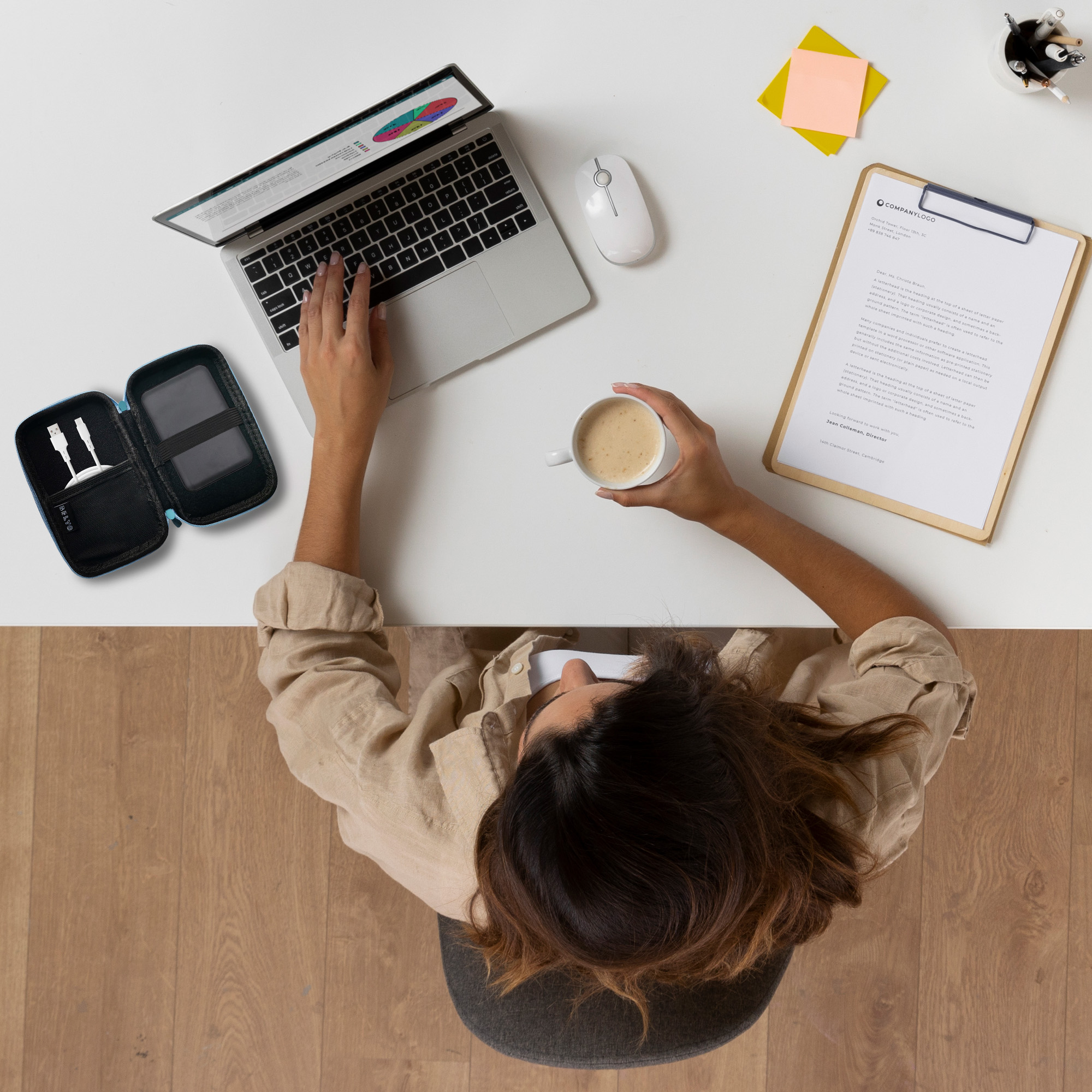Mujer en el escritorio usando una laptop, sosteniendo café. Hay un ratón, un estuche, un bloc de notas y un portalápices.