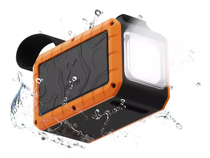 Altavoz impermeable naranja y negro con correa negra. Gotas de agua alrededor. El altavoz tiene una luz clara.
