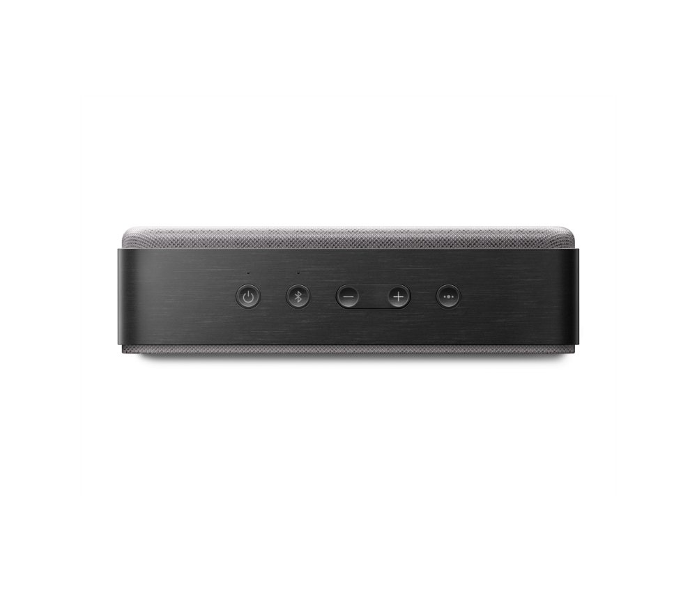 Egy fekete téglalap alakú hangszóró gombokkal. Szürke hálós teteje van. A gombok között van a bekapcsolás, Bluetooth, hangerő fel/le, stb.