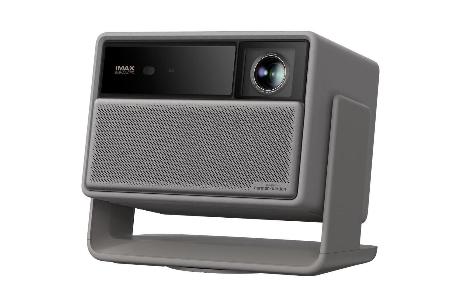 Egy szürke projektor hangszóróráccsal, lencsével és állvánnyal. 'IMAX Enhanced' és 'harman/kardon' márkajelzéssel.