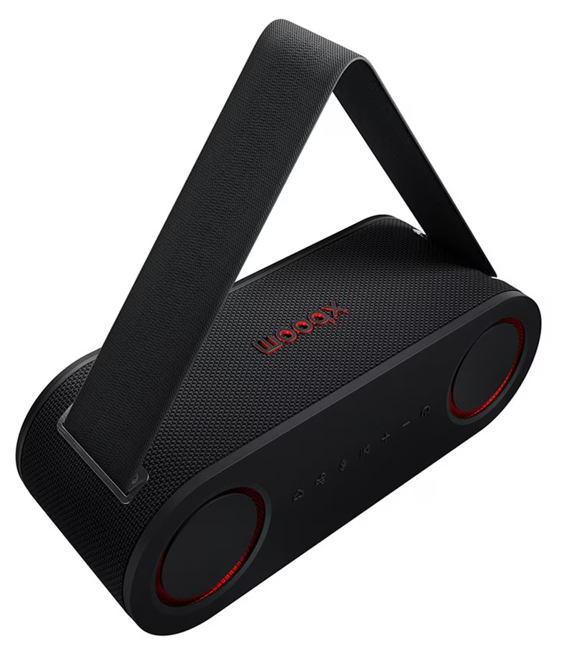Czarny głośnik przenośny z czerwonymi akcentami i uchwytem. Głośnik ma napis 'woox' w kolorze czerwonym.