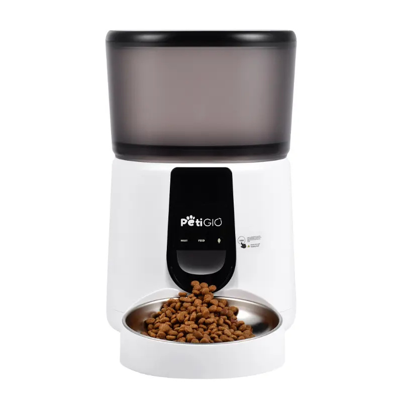 Biało-czarny automatyczny podajnik karmy dla zwierząt PetiGio. Brązowa karma jest dozowana do miski ze stali nierdzewnej. Na górze znajduje się ciemnoszary pojemnik.