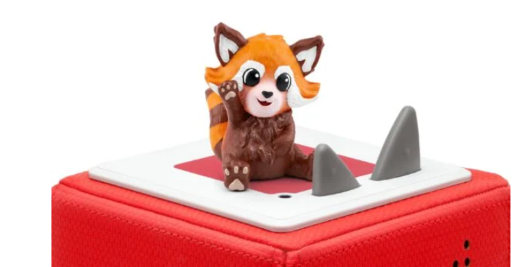 Ein rotes Panda-Spielzeug auf einer roten Box. Der Panda winkt. Zwei graue Flossen befinden sich oben auf der Box.