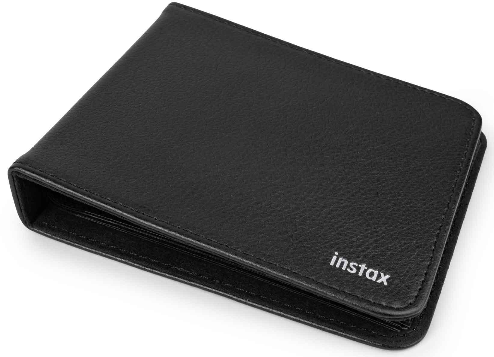 Fekete bőr fotóalbum, 'instax' felirattal a jobb alsó sarokban. Kicsit nyitva van, látszanak a lapok.