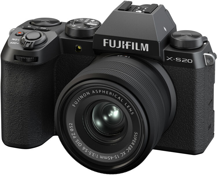 Egy fekete Fujifilm X-S20 fényképezőgép objektívvel. Különböző tárcsák és gombok találhatók rajta. Az objektíven szöveg, többek között 'Fujinon'.