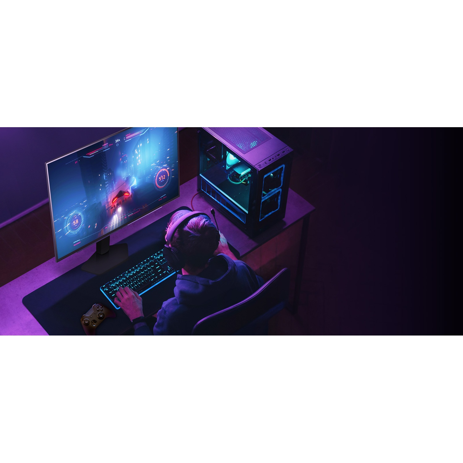 A person is gaming with a computer setup. A monitor displays a game. Keyboard, headset, and a game controller are visible.