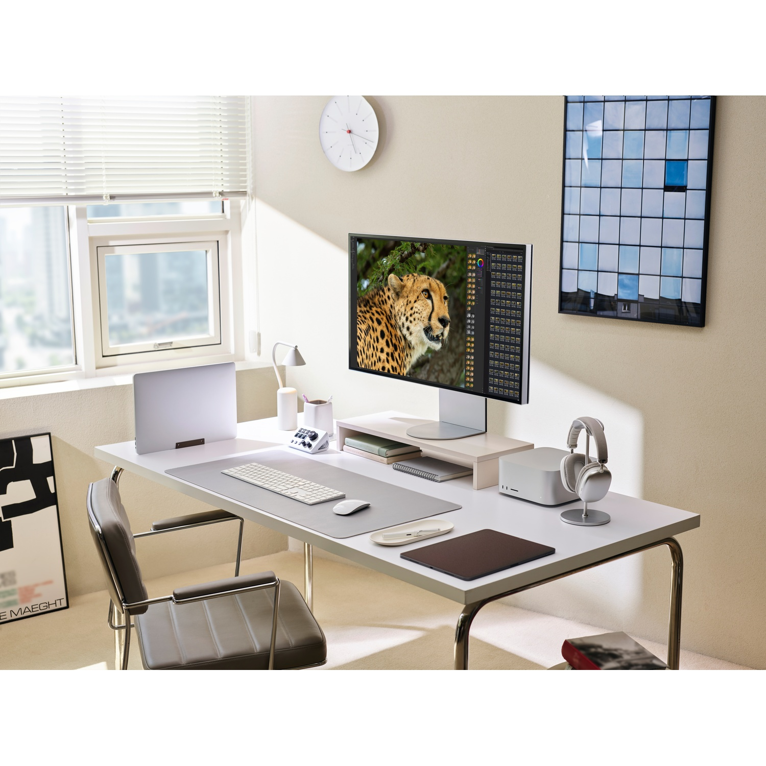 Une configuration de bureau moderne avec un écran d'ordinateur affichant une image de guépard, un casque et divers accessoires technologiques.