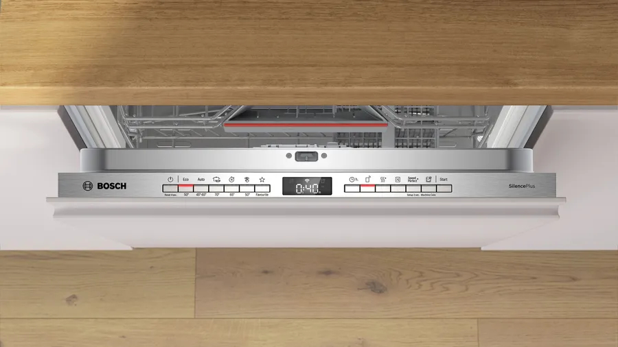Un lavavajillas Bosch SilencePlus abierto. Muestra el panel de control y las rejillas interiores, con madera arriba y abajo.