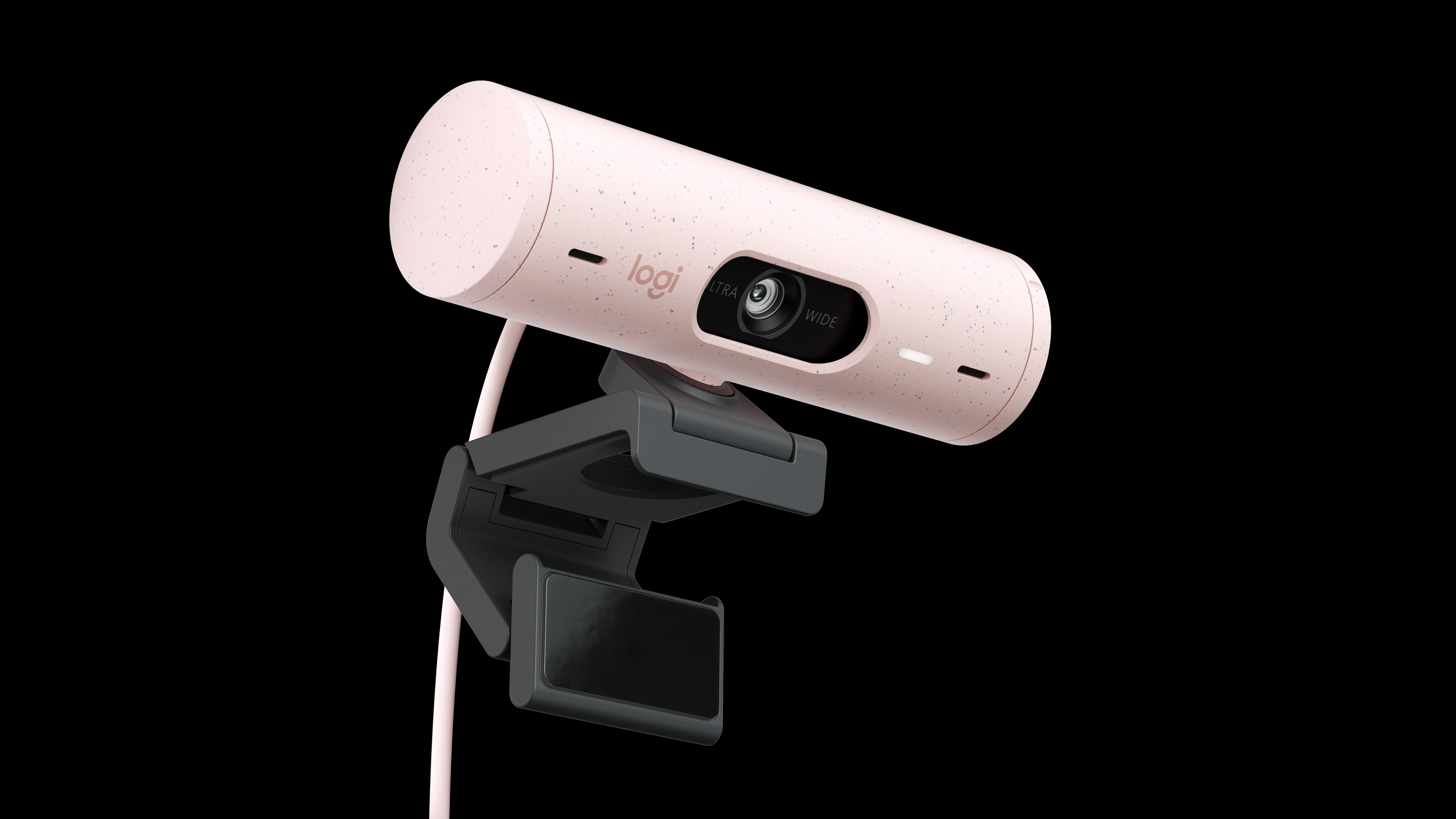 Eine rosa Logitech-Webcam mit schwarzer Halterung wird vor schwarzem Hintergrund gezeigt. Die Kamera ist zylindrisch.