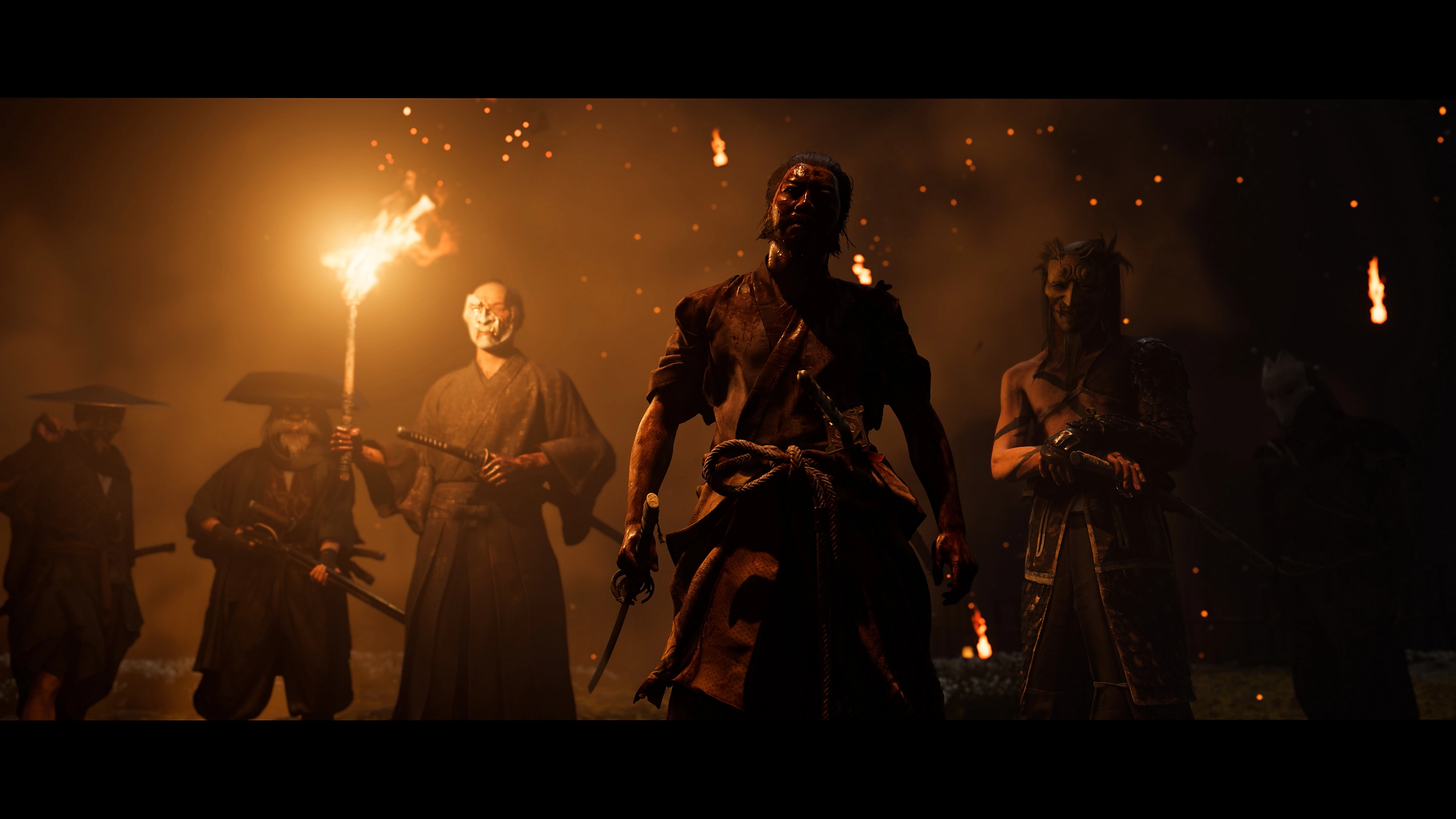 Grupa wojowników z mieczami i pochodniami stoi w ciemnym, ognistym otoczeniu. Jeden trzyma pochodnię, inni mają maski.
