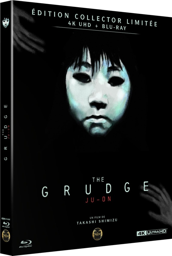 Couverture du film 'The Grudge'. Un visage pâle avec des yeux sombres est au centre. Le titre est en dessous, avec un fond sombre.