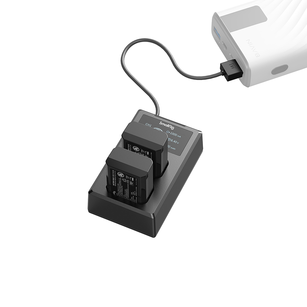 Chargeur de batterie SmallRig noir avec deux batteries. Une banque d'alimentation blanche est connectée par câble. Isolé sur fond blanc.