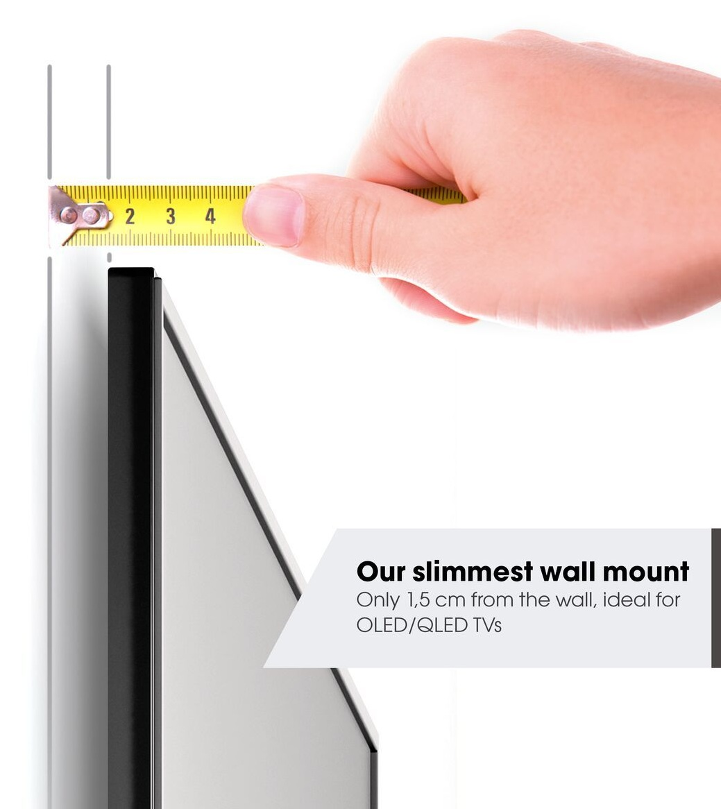 Ręka trzyma żółtą miarę blisko telewizora. Miara pokazuje 2, 3 i 4. Tekst: 'Nasz najsmuklejszy uchwyt ścienny'.