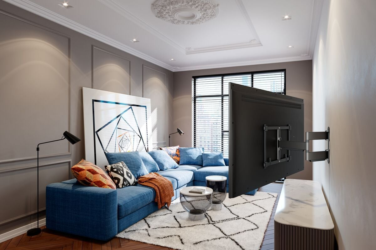 Salon z niebieską sofą, dużym telewizorem, białym dywanem i geometryczną grafiką. Okna z żaluzjami w tle.