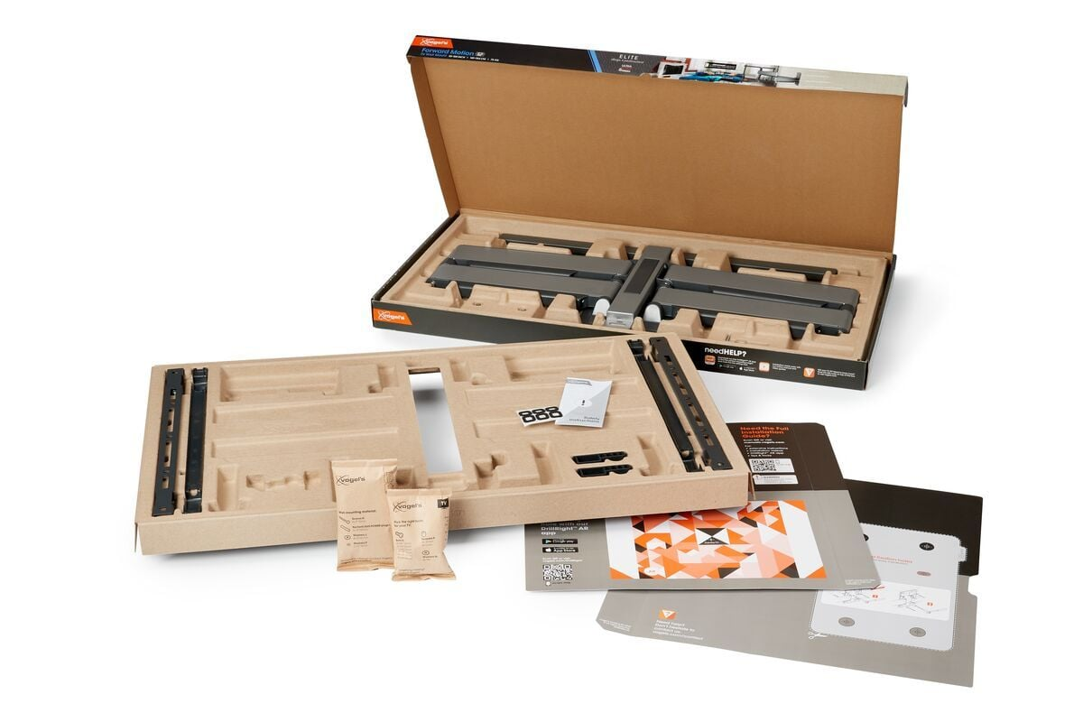 Otwarte pudełka ze sprzętem do montażu telewizora, instrukcjami i małymi częściami. Opakowanie kartonowe. Szare i czarne elementy metalowe.