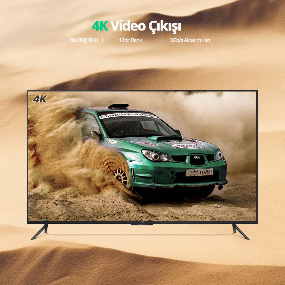 Yeşil bir araba kumdan geçiyor, 4K TV'de gösteriliyor. TV'nin siyah çerçevesi ve standı var.