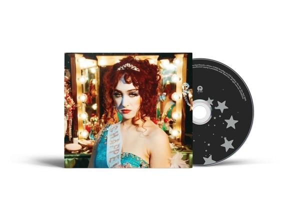 Albumcover: Frau mit roten Haaren und Tiara. Eine CD mit Sternen befindet sich neben dem Album. Lichter im Hintergrund.