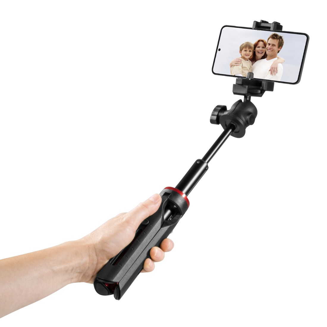 Bir el, bir aile fotoğrafı gösteren bir telefonla selfie çubuğunu tutuyor. Çubuk siyah ve kırmızı, beyaz bir zemin üzerinde.