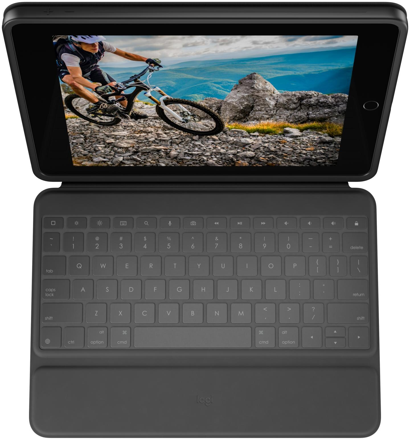 Un iPad avec un étui clavier affiche un VTTiste sur un sentier rocheux. Le clavier est gris avec des touches blanches.