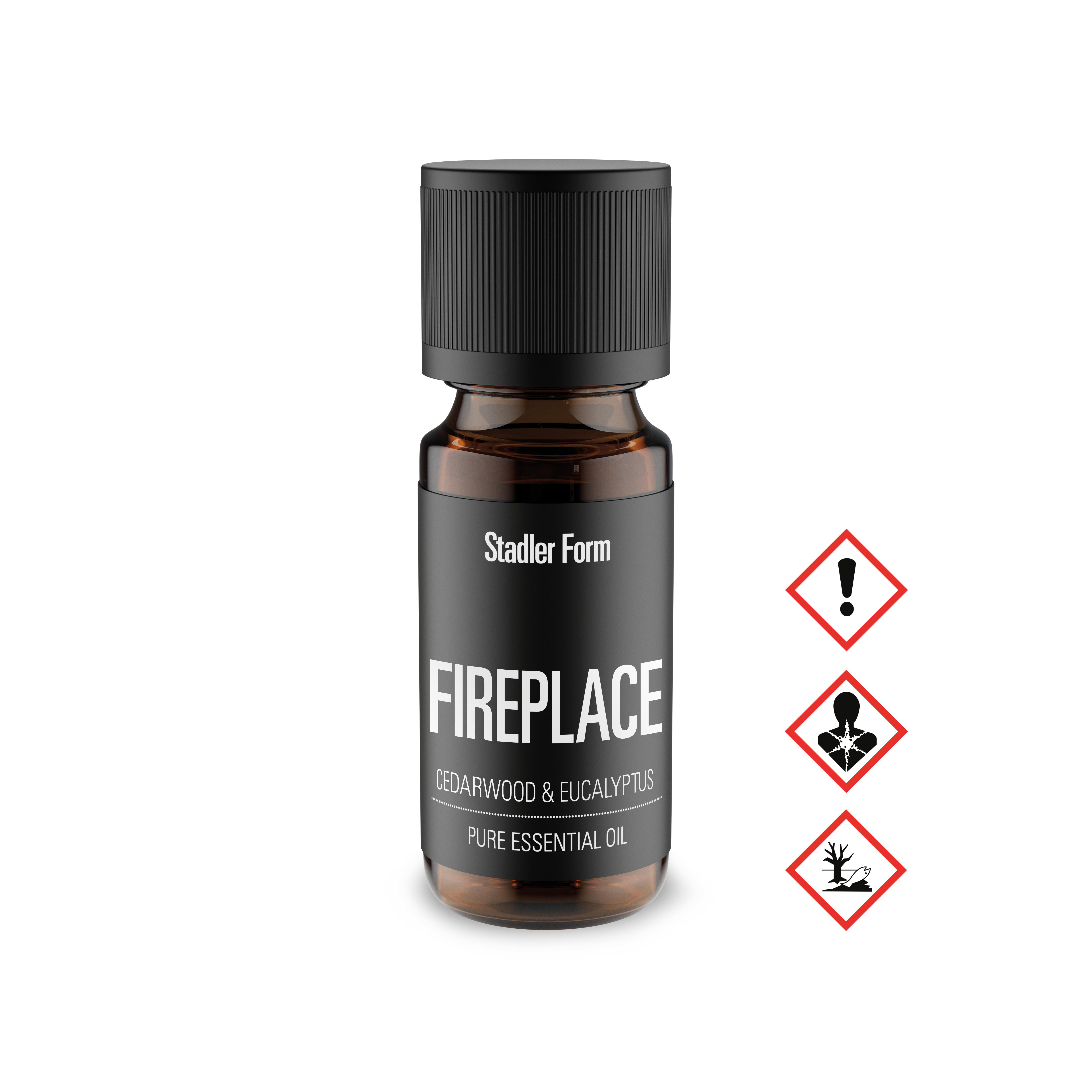 Flasche ätherischen Öls mit der Aufschrift 'Fireplace'. Enthält Zedernholz und Eukalyptus. Warnsymbole rechts.