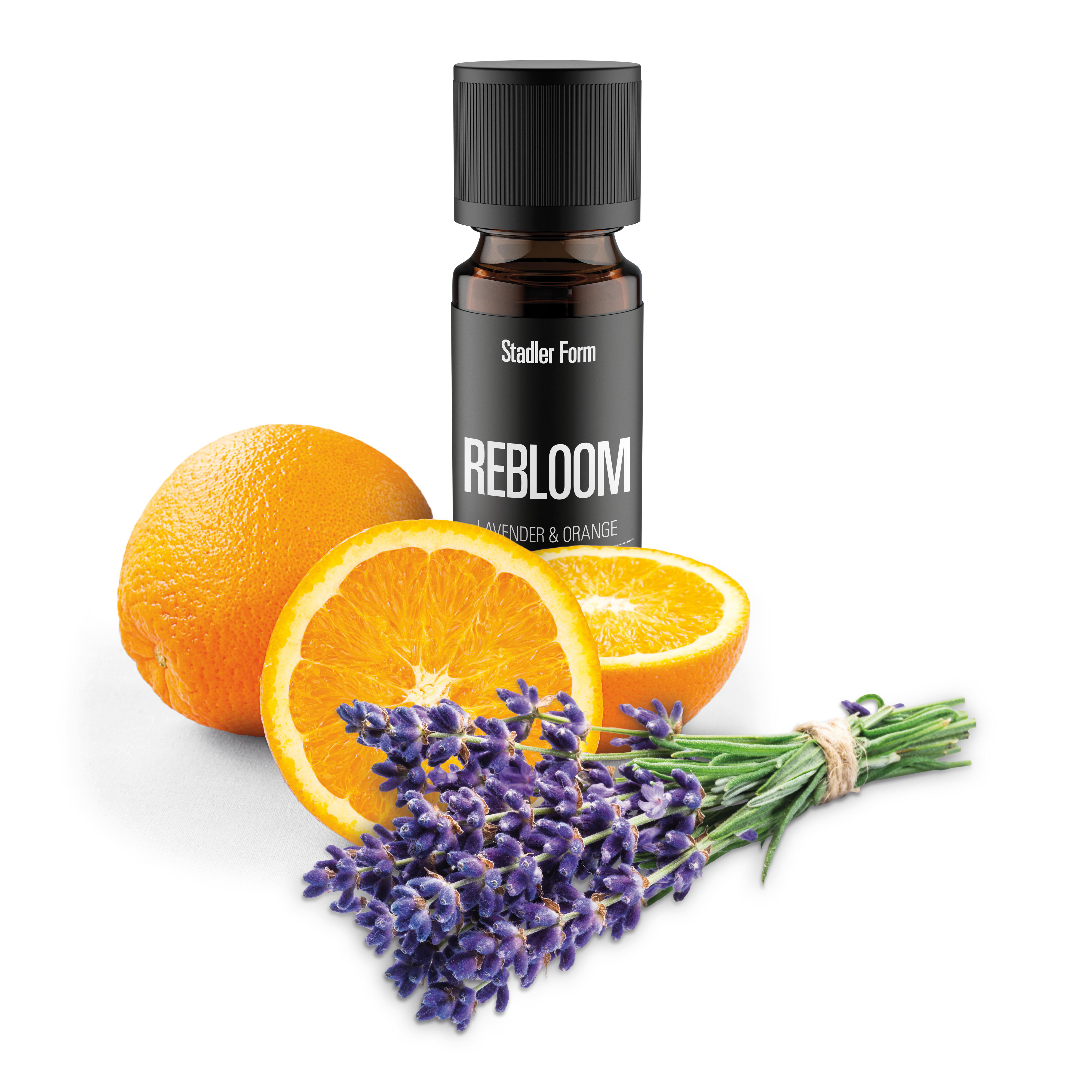Das Bild zeigt eine Flasche ätherischen Öls, Orangen und Lavendel mit Rosmarin. Auf der Flasche steht 'REBLOOM' und 'Lavender & Orange'.