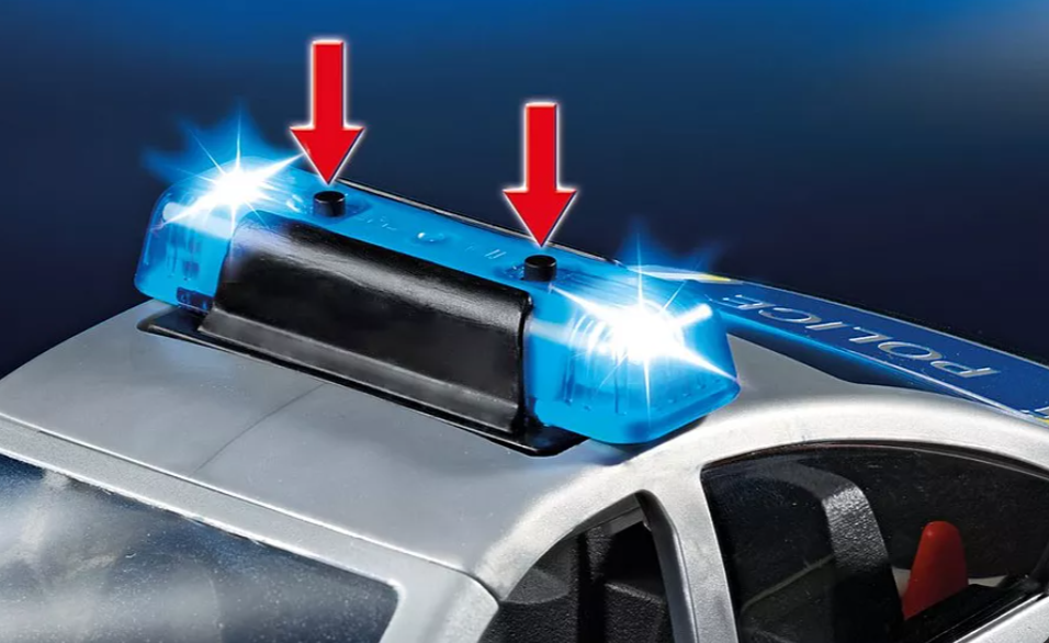 Nahaufnahme der blinkenden blauen Lichter eines Spielzeug-Polizeiautos. Pfeile zeigen auf die Lichter. Das Wort 'POLIZEI' ist sichtbar.