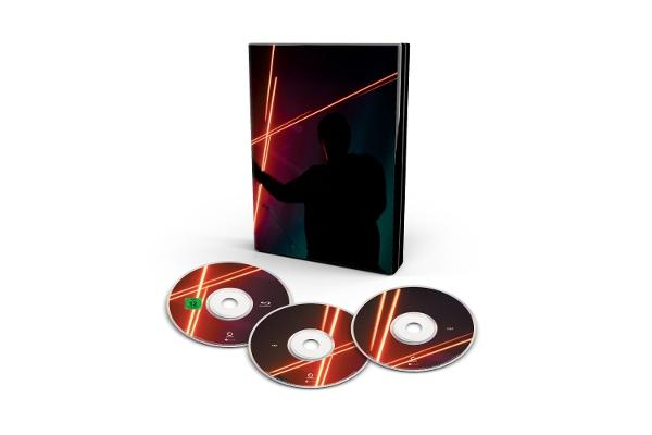 Eine DVD-Box mit drei Discs. Die Box zeigt eine Silhouette einer Person mit roten Neonlichtern. Discs sind rot und schwarz.