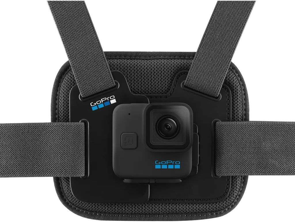 Egy fekete GoPro kamera egy mellkasra rögzíthető hámra van szerelve. Szürke pántok és egy fekete hálós hátlap látható. GoPro logó felül és alul.