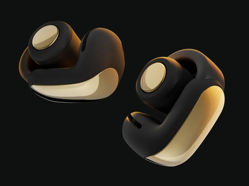 Dwa bezprzewodowe słuchawki o czarno-złotym designie. Złote akcenty na czarnym korpusie, na ciemnym tle.