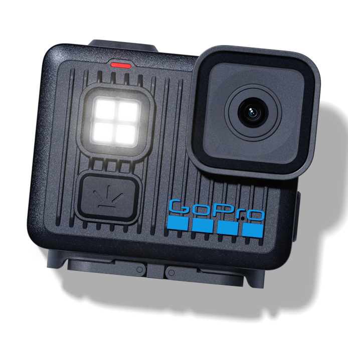 Czarna kamera GoPro z kwadratowym obiektywem, jasnym światłem i logo GoPro. Jest na białym tle.