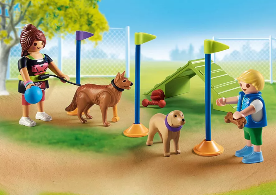 Eine Hundeparkszene mit Spielfiguren: zwei Hunde, zwei Kinder und Geräte für Agility. Ein Kind hält einen Knochen, das andere eine Leine.