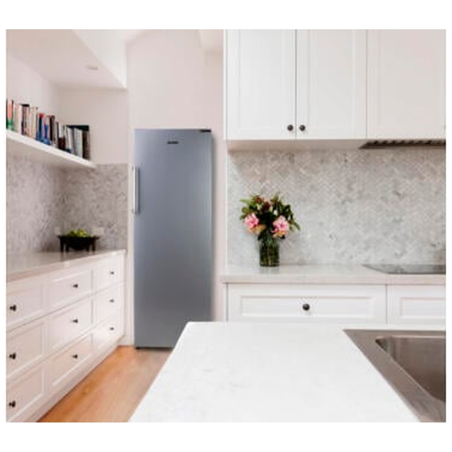 Une cuisine moderne avec des armoires blanches, un réfrigérateur en acier inoxydable et un bouquet de fleurs. Plancher en bois et dosseret en marbre.