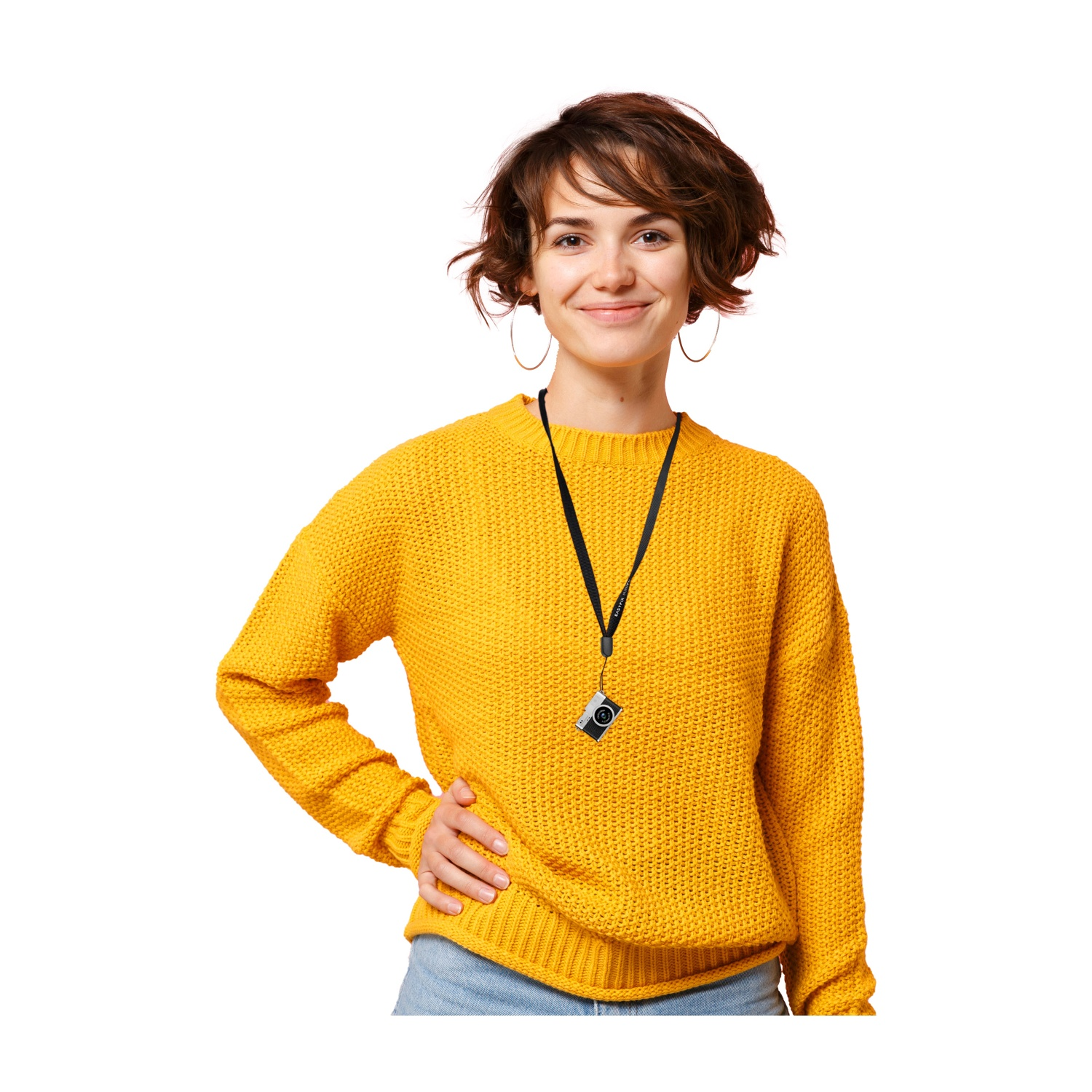 Donna sorridente con maglione giallo, orecchini a cerchio, mano sui fianchi. Una piccola fotocamera è appesa al collo.