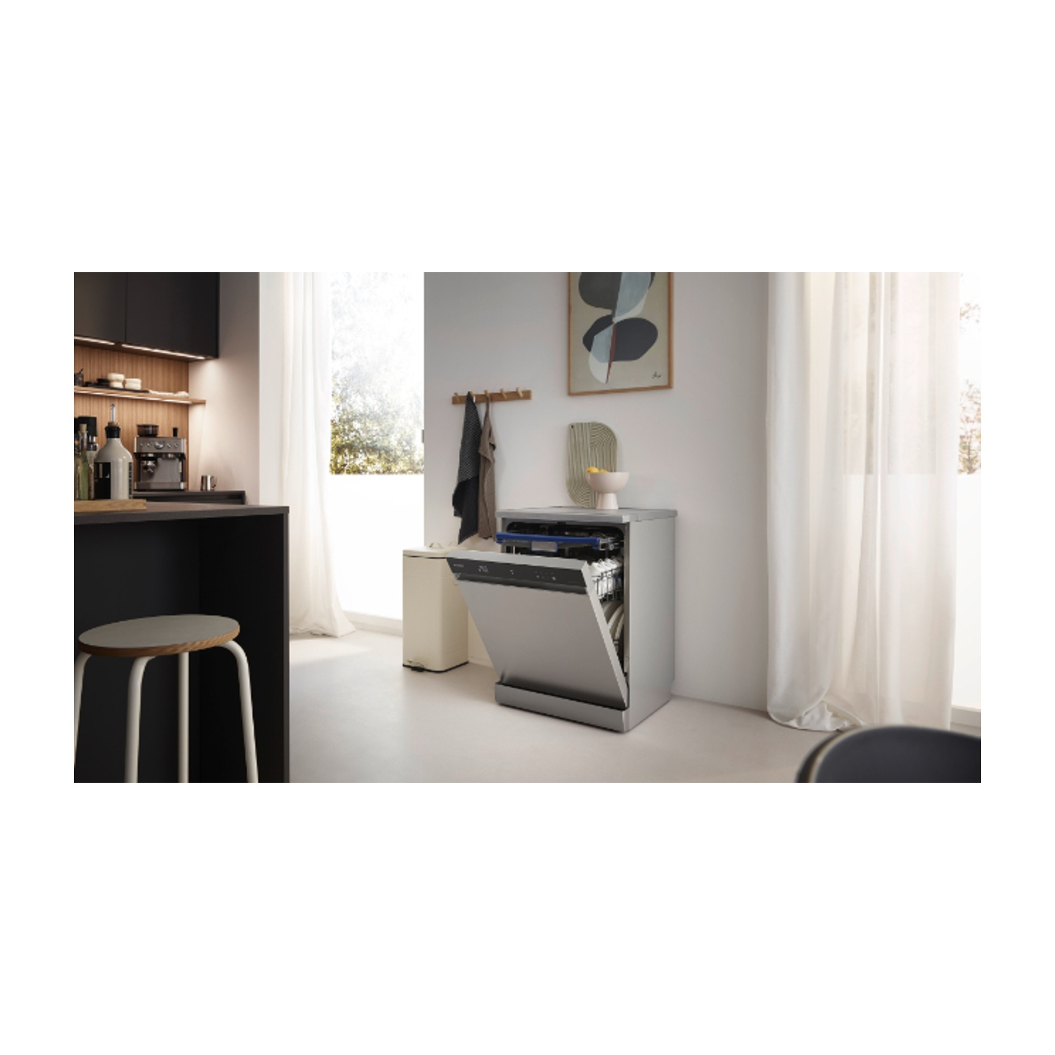 Una scena di cucina con una lavastoviglie aperta. Uno sgabello, armadi e una finestra sono sullo sfondo. Tende a destra.