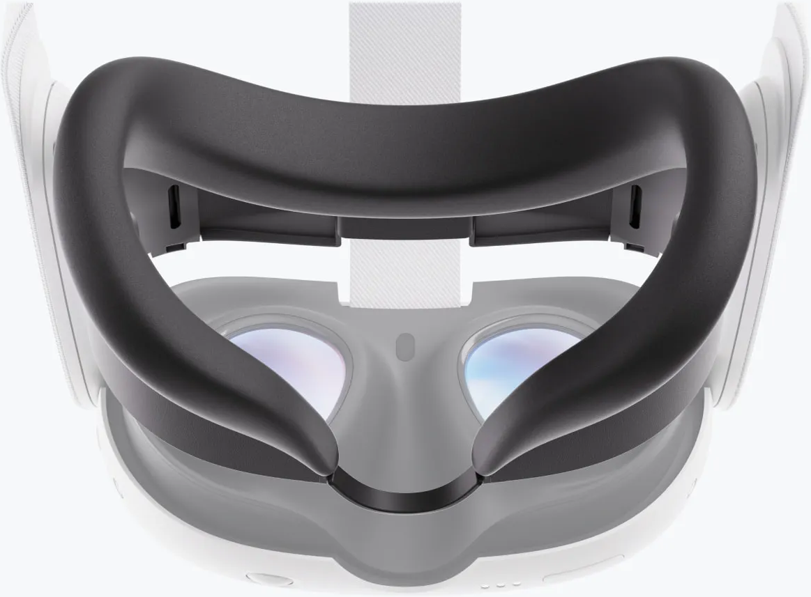 Un visore VR con un cuscinetto facciale grigio scuro. Le lenti sono visibili. Sono visibili anche il cinturino e la montatura bianchi.